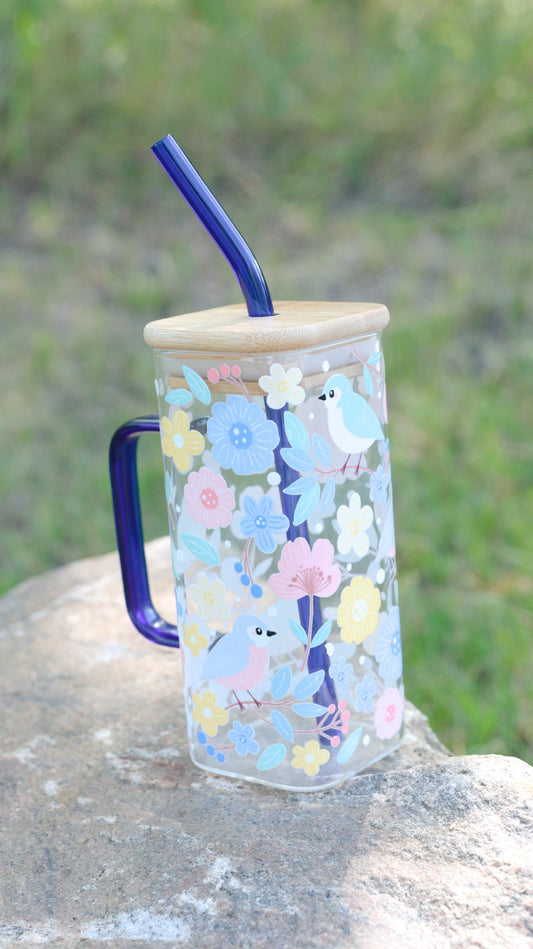 Decorative glass mug with floral and animal design on a natural background