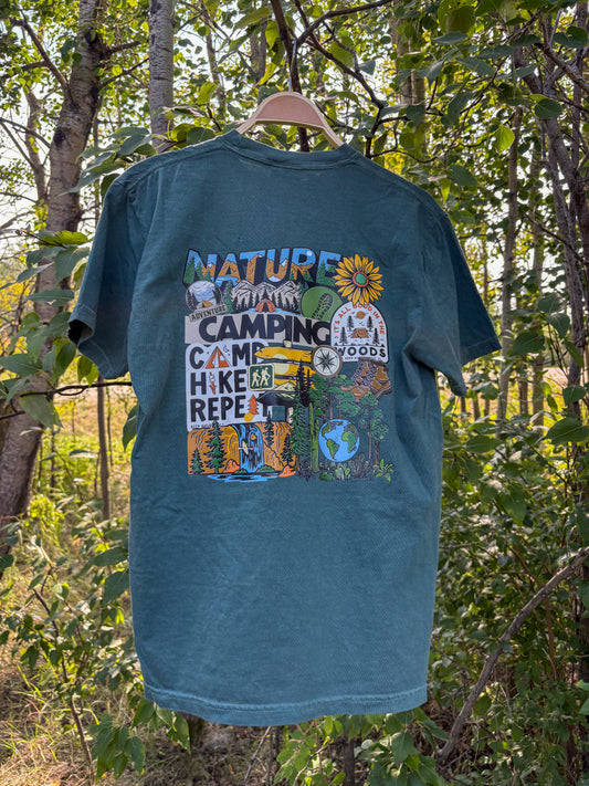 Green t-shirt with nature-themed graphics and text hanging in a forest setting